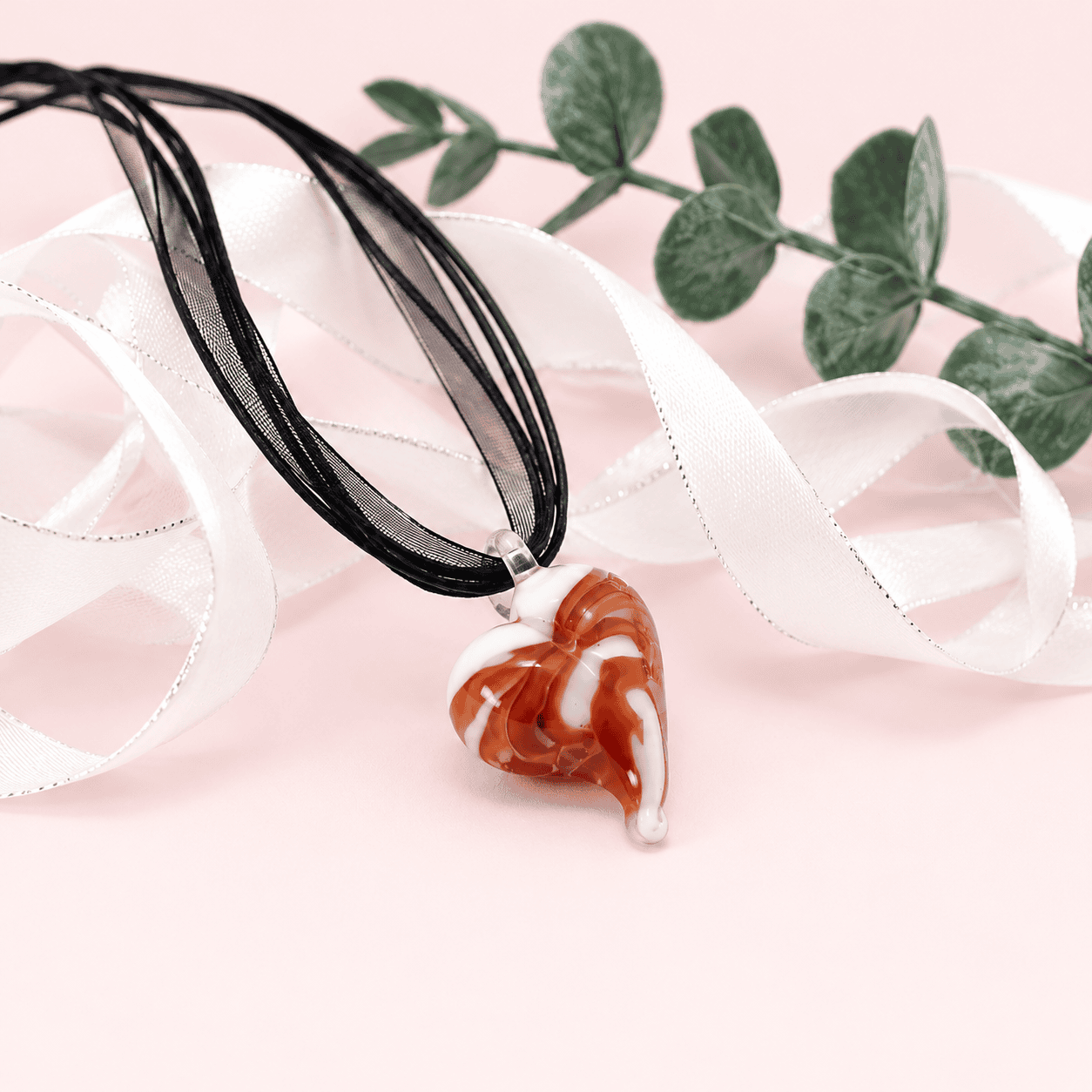 Détail du pendentif cœur en verre filé aux nuances marron et blanches