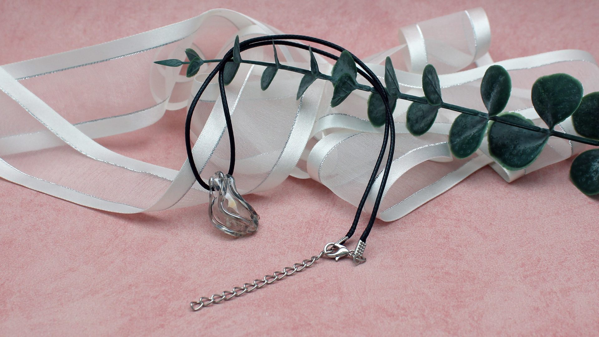 Pendentif artisanal réalisé en cristal recyclé grâce au filage de verre au chalumeau. Cette création unique illustre l’artisanat écologique et les bijoux éco-responsables.